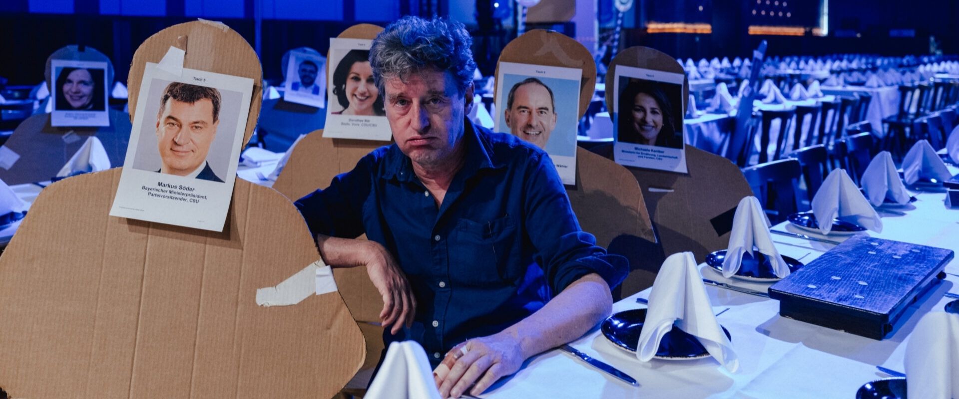 Richard Oehmann, Zukunftsforum, Forum, Altoetting, Derbleckereien, Foto Jan Saurer, Monacoshots Ein Mann sitzt an einem Tisch.