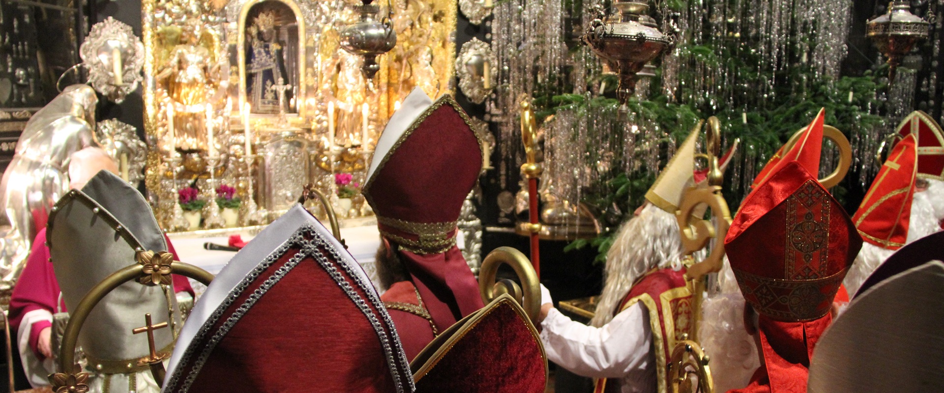 Nikolaus Wallfahrt, Altötting, Bild Christian Wieser Nikoläuse in rotem Gewand in einer Kirche.