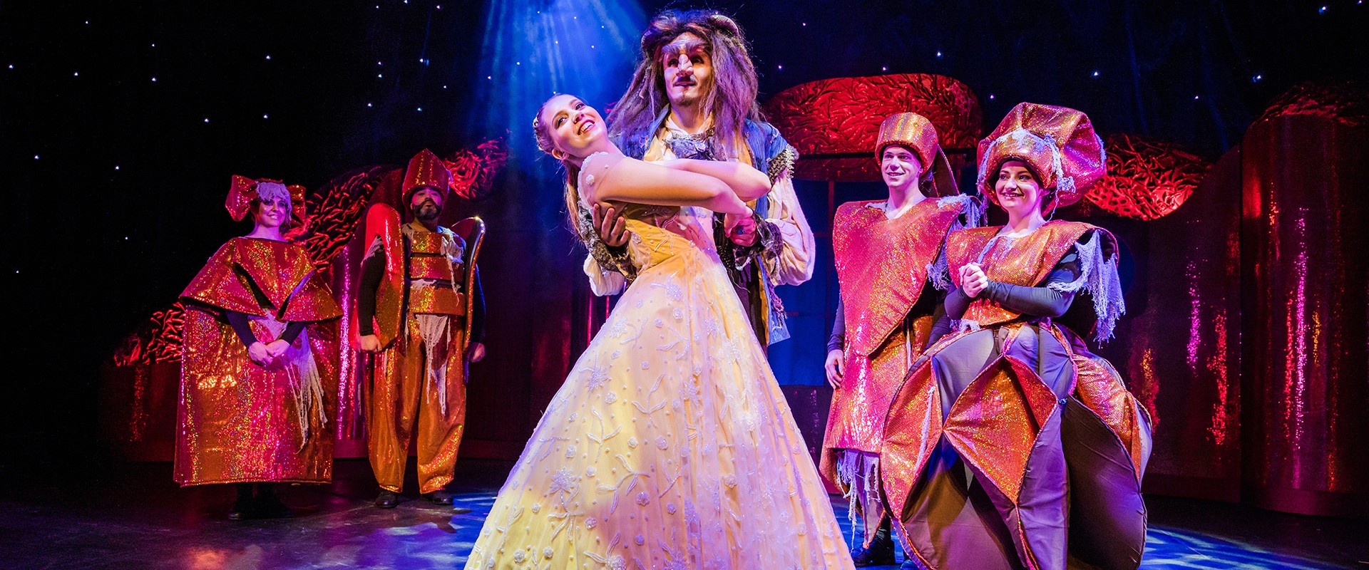 Die Schoene und das Biest, Theater Liberi, Forum Altoetting, Bild Nilz Boehme Ein Mädchen im Ballkleid tanzt mit einem Mann in furcheinfloessender Maske.