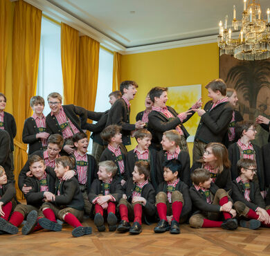 Gruppenbild des Tölzer Knabenchores in Tracht in einem Innenraum
