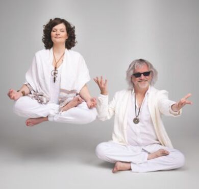 Das Kabarett-Duo Petzenhauser & Wählt in weißen Outfits bei Yoga-Posen mit esoterischem Schmuck und humorvoll übertriebenen Handbewegungen.