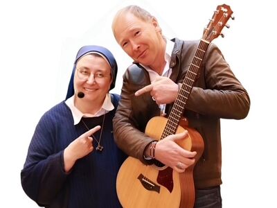 Schwester Teresa Zukic, Warm um Herz, Forum Altötting, Bild Veranstalter Eine Frau und ein Mann mit Gitarre.