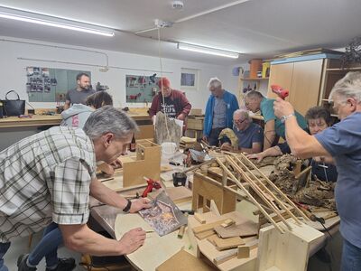 Teilnehmer des Krippenbaukurses bauen gerade an ihrer Krippe.