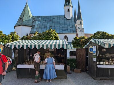 Klostermarkt Altötting, Foto Tourismusbüro Altötting Zwei Menschen stehen vor einem Stand am Altöttinger Klostermarkt.