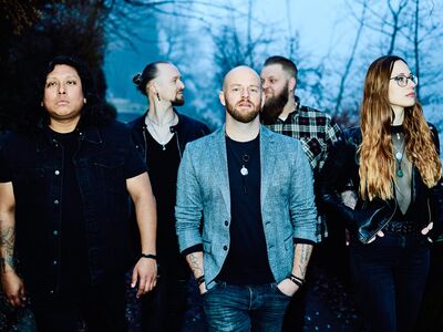 Vier Männer und eine Frau in dunkler Bekleidung stehen nebeneinander.