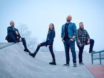 Roxton, Forum Altoetting, Abriss, Vorband Ragetrack, Bild Band Drei Männer und eine Frau in dunkler Bekleidung stehen nebeneinander.