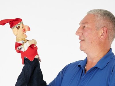 Chiemsee Kasperl, Forum, Altoetting, Bild Mikat Ein Mann hält eine Handpuppe in seiner Hand.