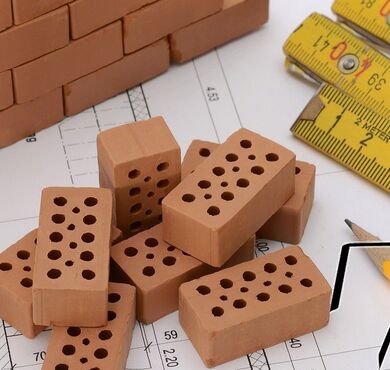 Ziegelsteine, Architektenpläne und Meterstab