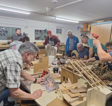 Teilnehmer des Krippenbaukurses bauen gerade an ihrer Krippe.