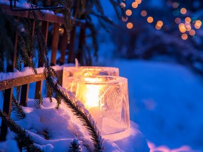 Kerzen stehen in einer schneebedeckten Landschaft.