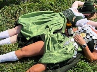 Zwei Frauen im Dirndl auf einer Wiese liegend