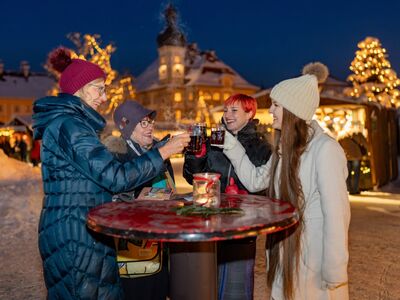 Führung Herzerwärmendes Altötting im Advent, Foto Dirschl Vier Frauen stoßen mit einem Glühwein am Christkindlmarkt an.