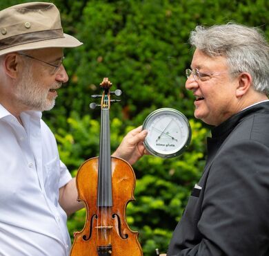 Harald Lesch und Martin Walch blicken sich an vor einer Naturkulisse