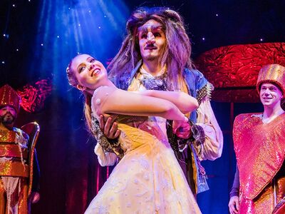 Die Schoene und das Biest, Theater Liberi, Forum Altoetting, Bild Nilz Boehme Ein Mädchen im Ballkleid tanzt mit einem Mann in furcheinfloessender Maske.