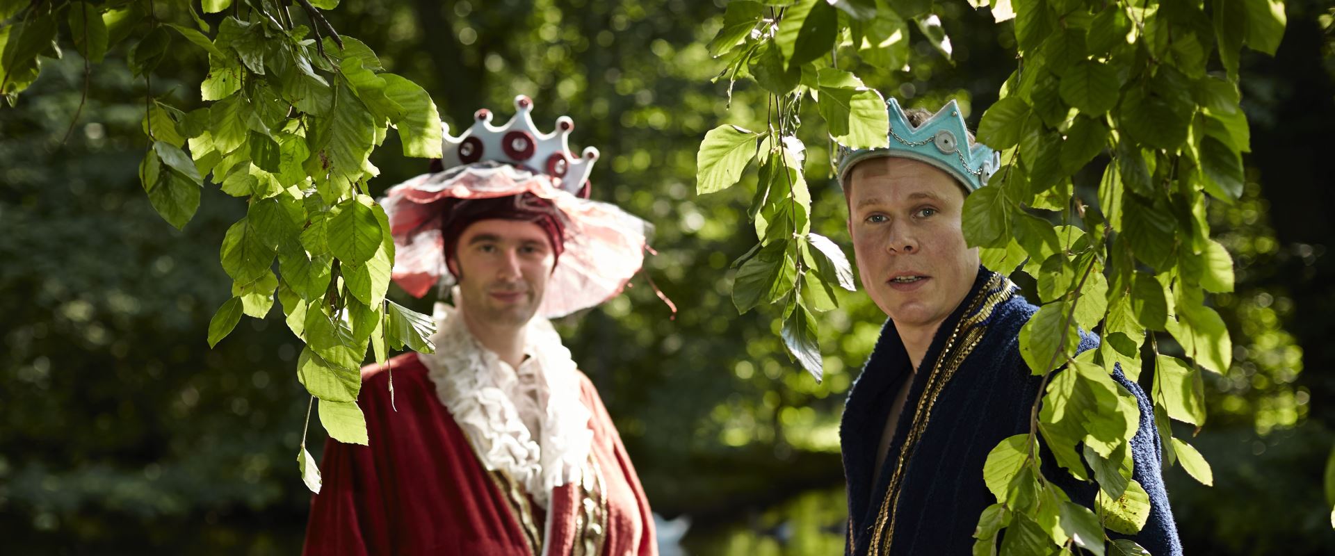 Die beiden Freunde Valentin und Waldemar stehen als König und Königin in einem Wald.
