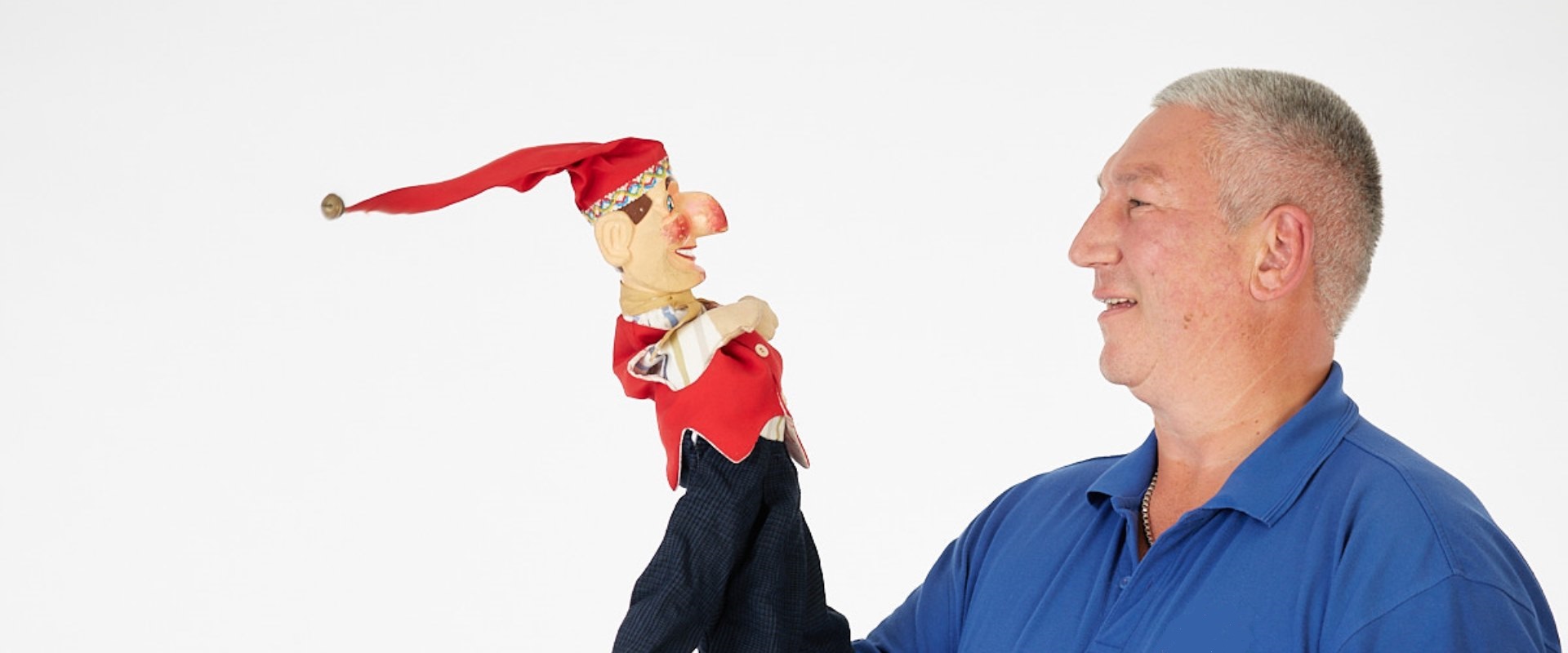 Ein Mann hält eine Handpuppe in seiner Hand. 