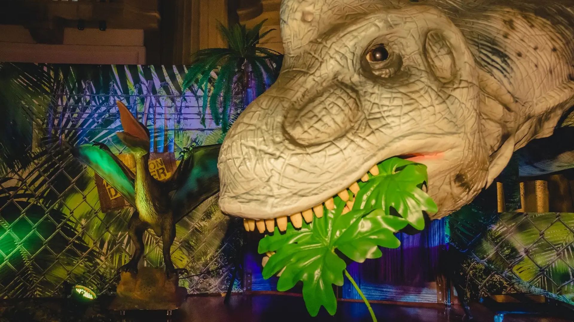 Ein Dinosaurier frisst ein Blatt einer Dschungelpflanze.