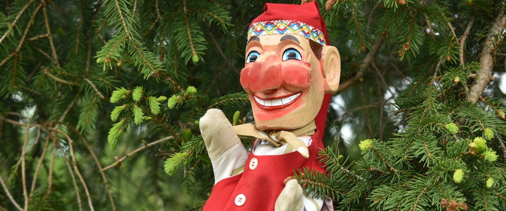 Eine Handpuppe vor einem Weihnachtsbaum.
