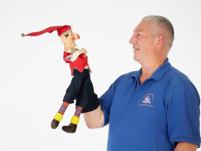 Chiemsee Kasperl, Forum, Altoetting, Bild Mikat Ein Mann hält eine Handpuppe in seiner Hand.
