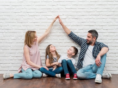 Mein Zuhause, Immobilienmesse, Forum, Altötting, Bild Pixabay Eine Familie mit zwei kleinen Kindern sitzt vor einer weißen Wand.