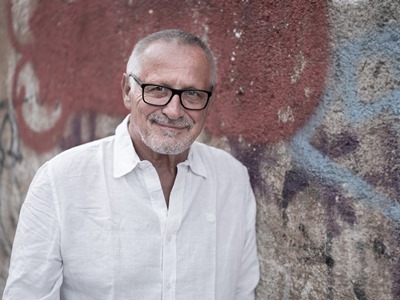 Liedermacher Konstantin Wecker blickt charmant in Richtung Kamera.