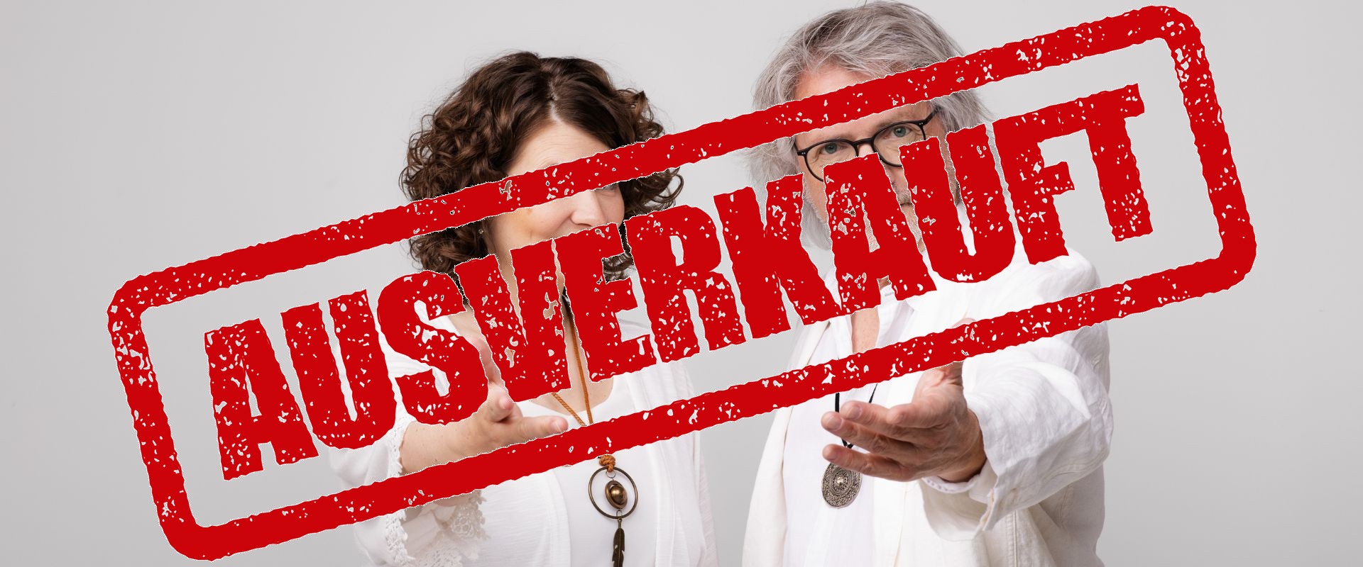 Das Kabarett-Duo Petzenhauser & Wählt in weißen Outfits bei Yoga-Posen mit esoterischem Schmuck und humorvoll übertriebenen Handbewegungen.