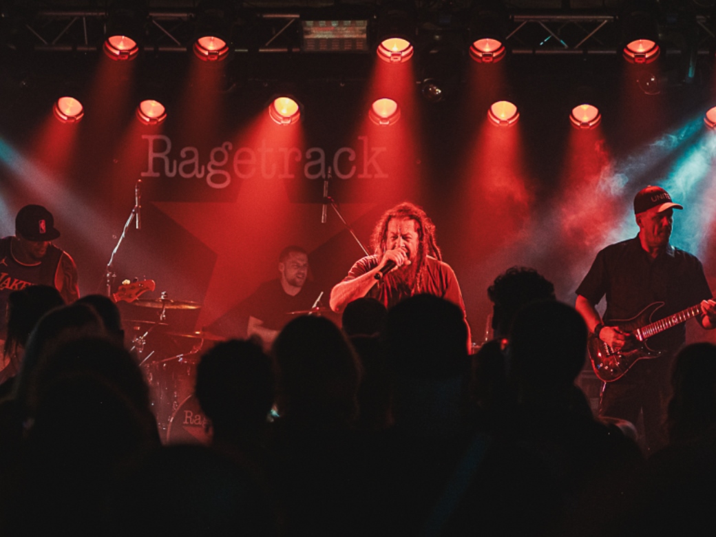 Band auf einer Bühne mit rotem Bühnenlicht. 