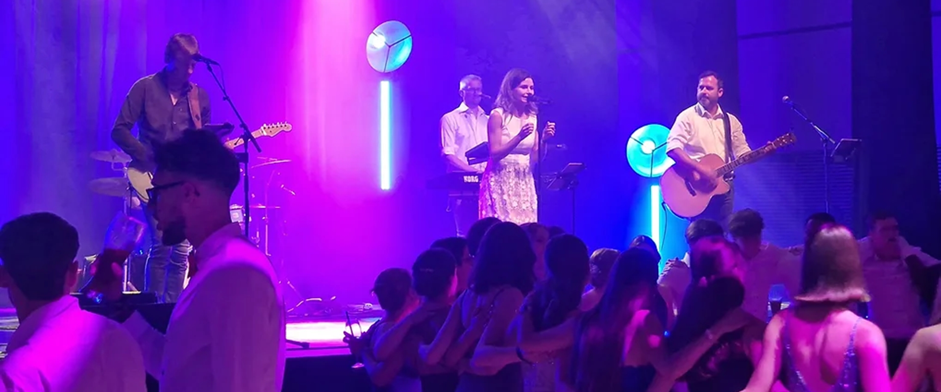 Eine Band auf einer Bühne mit farbigem Licht.