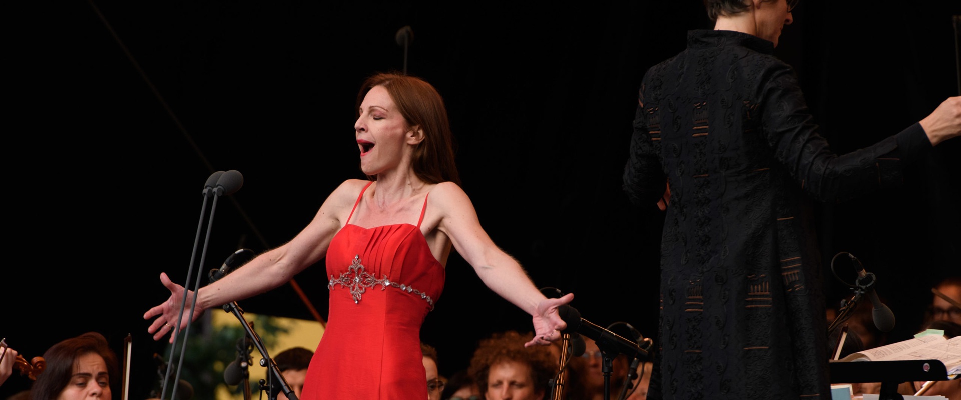 Eine Opernsängerin in einem roten Abendkleid.