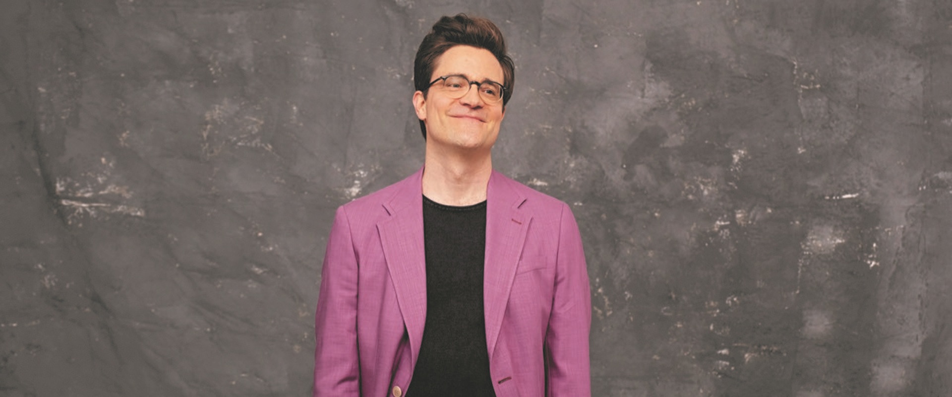 Bodo Wartke, Wunderpunkt, Forum Altötting, Foto Reimkultur Ein Mann in lilafarbenem Anzug vor dunklem Hintergrund.