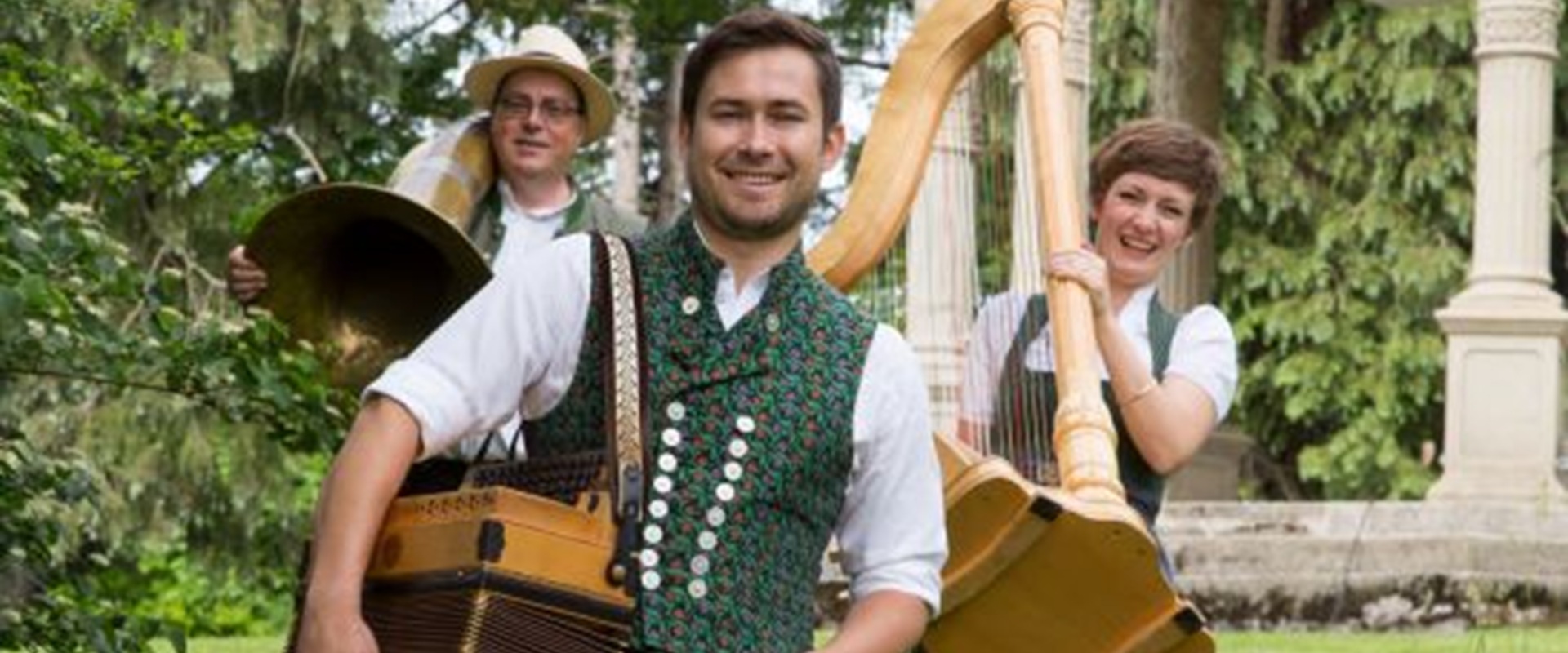 Drei junge Menschen mit Ziehharmonika, Harfe und Schlagzeug.
