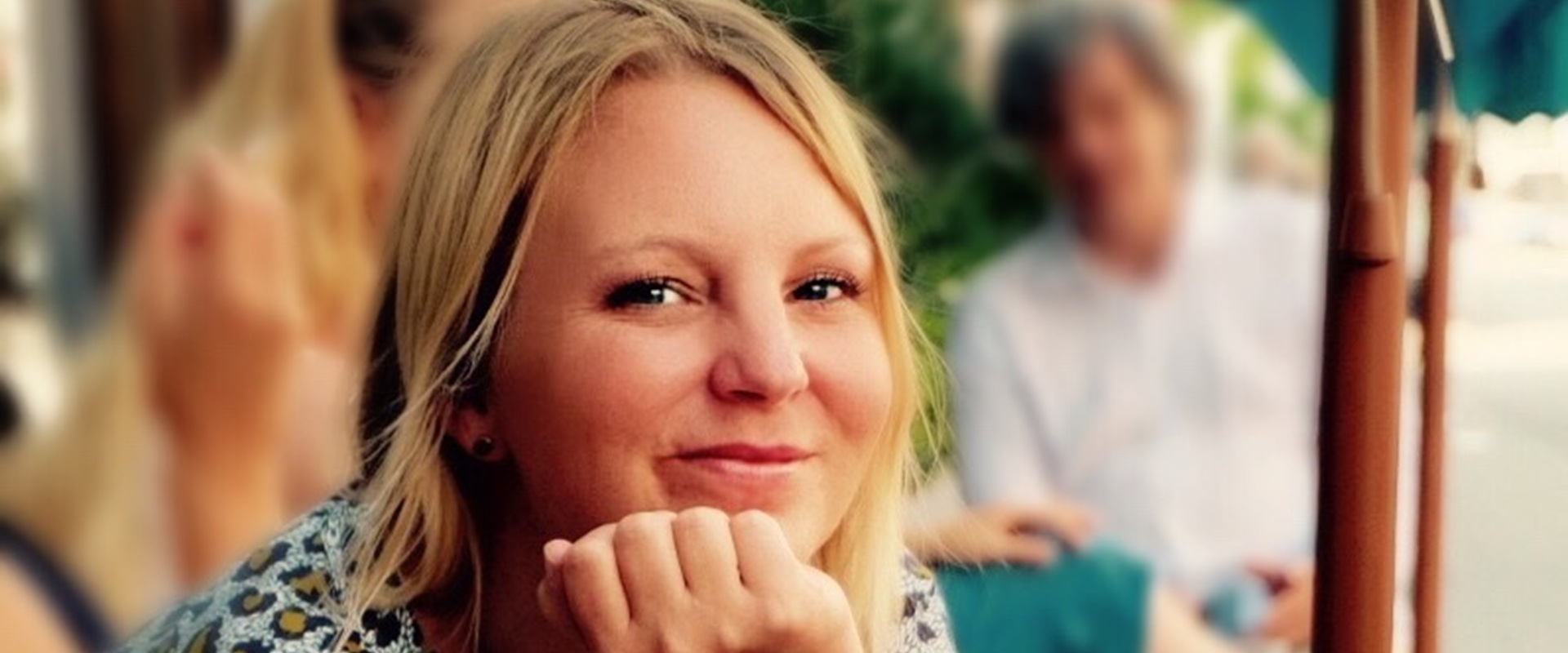 Eine Frau sitzt in einem Straßencafe.
