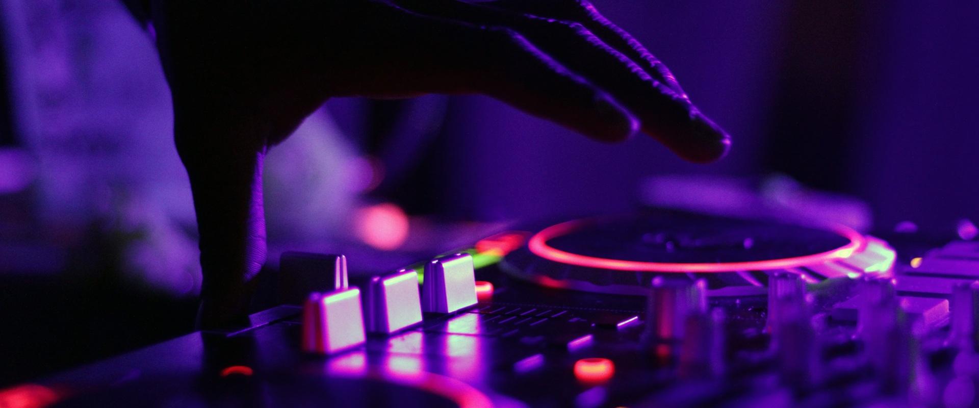 Eine Hand im Gegenlicht an den Turntables.