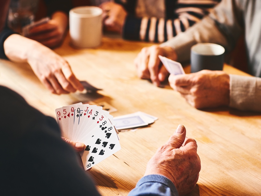 Senioren, Spielenachmittag, BRK Seniorenzentrum, Stadt Altötting, Bild IStock Senioren sitzen an einem Tisch und spielen ein Kartenspiel