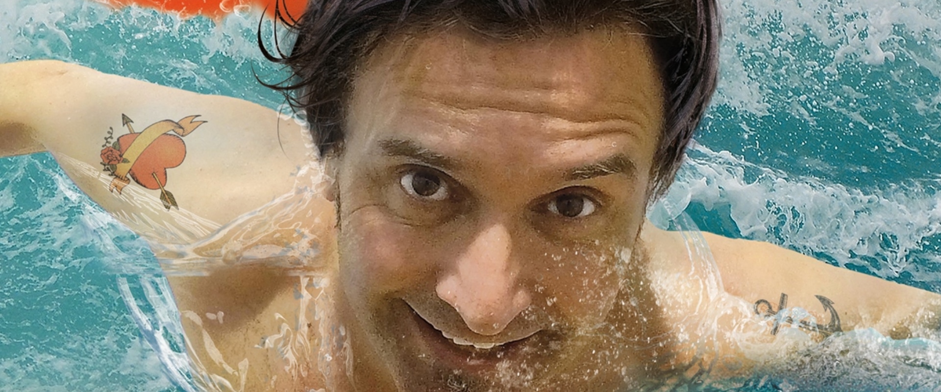 Der Comedian Chris Boettcher schwimmt im Wasser mit einem Rettungsring. Sein neues Programm heißt Freischwimmer.