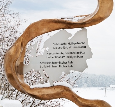 Eine goldene Stele auf dem Friedensweg der Franz Xaver Gruber Gemeinschaft zeigt den Text zum Thema Europa.