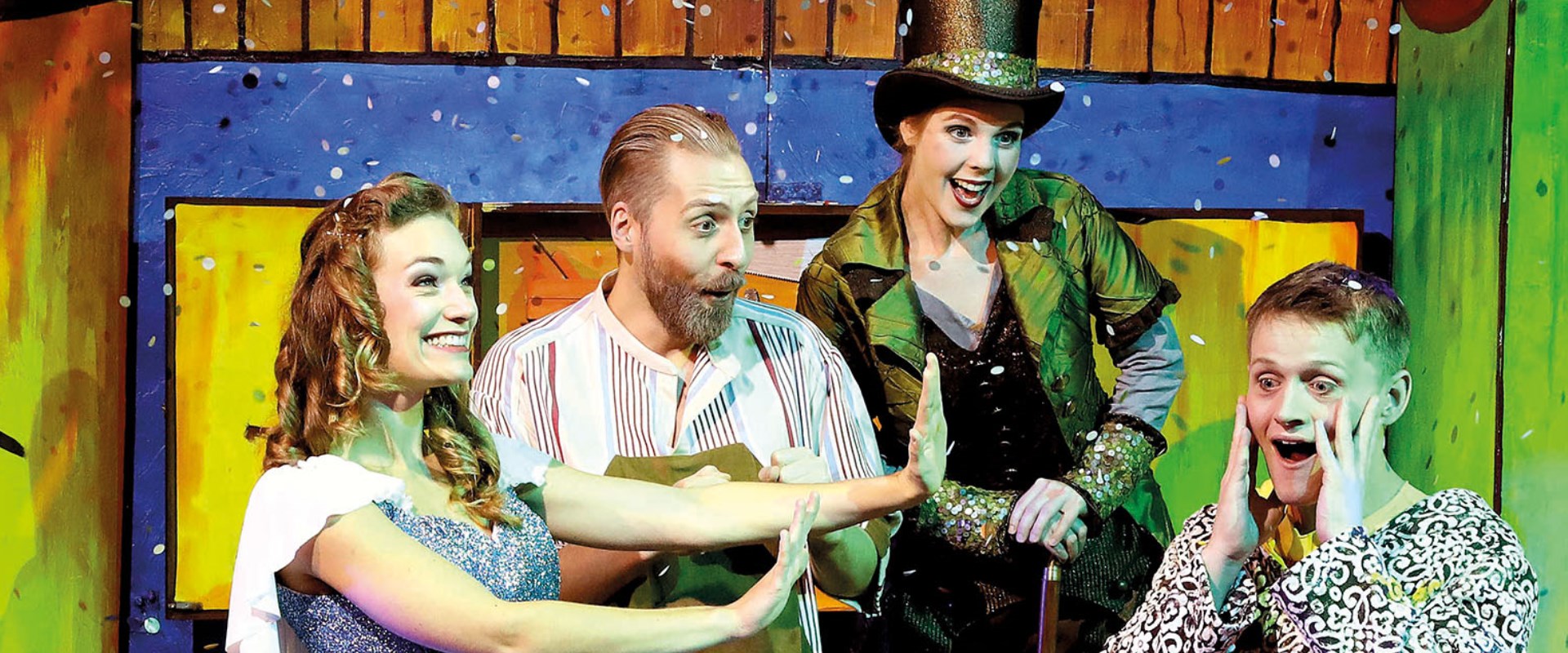 Pinocchio und seine Freunde erleben viele Abenteuer. Die Schauspieler lachen gemeinsam auf der Bühne.