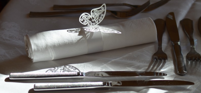 Ein Hochzeitsgedeck mit einem Serviettenring, auf dem ein Schmetterling ist, im Altöttinger Forum.