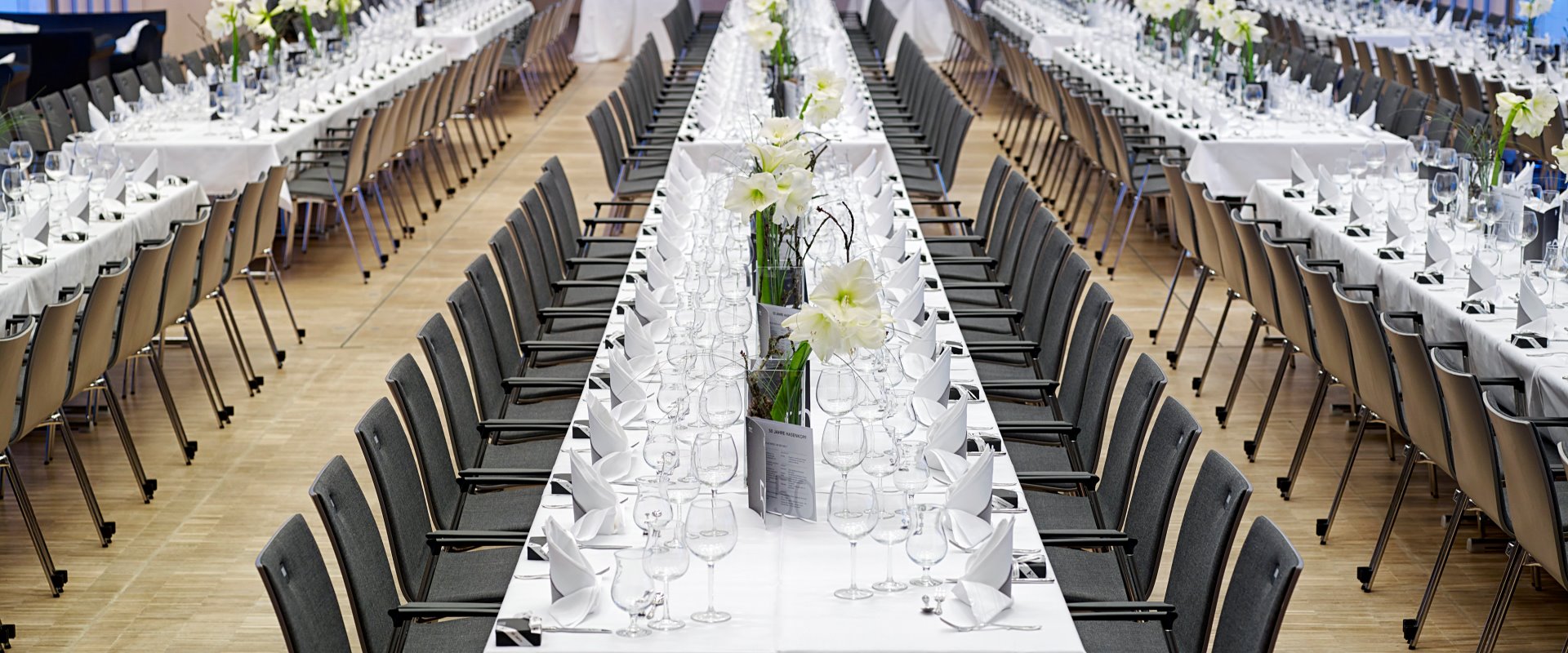 Raiffeisen-Saal Catering Gala eckige Tische eingedeckt mit Dekoration