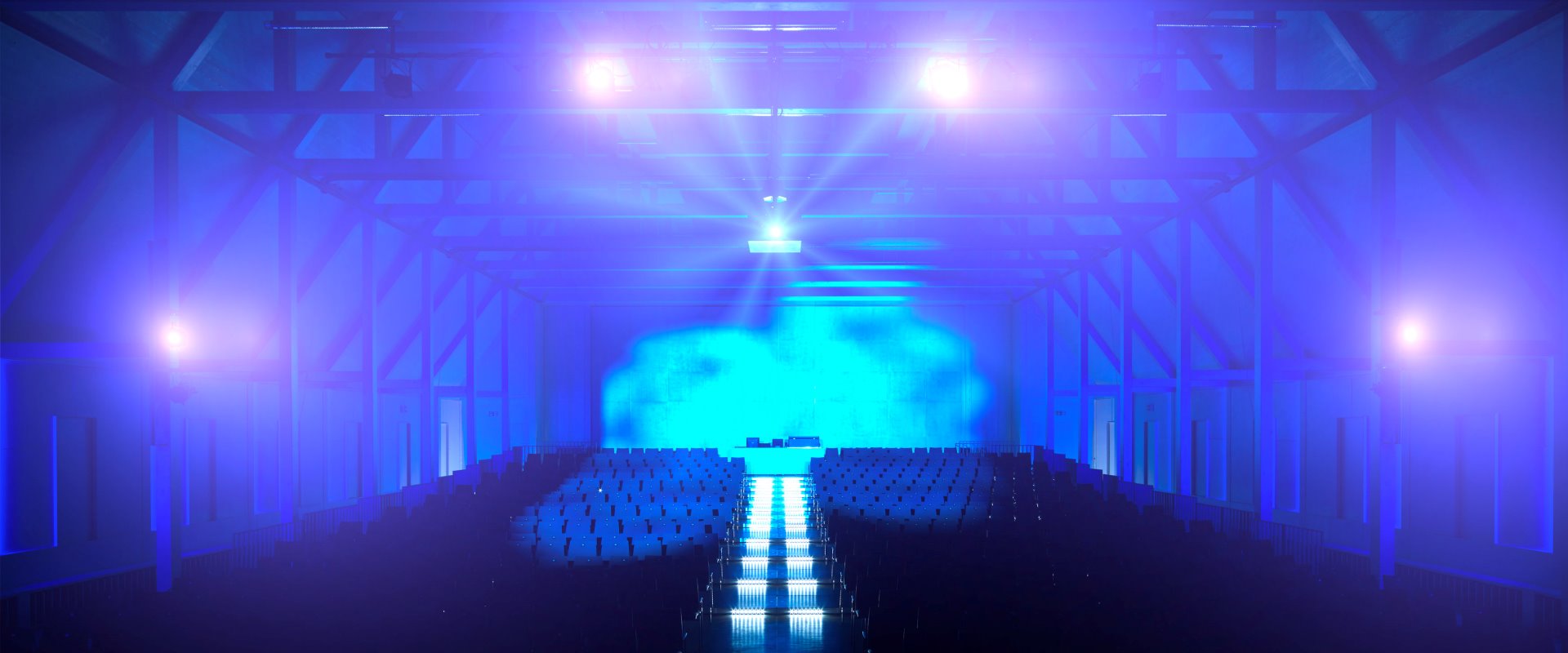 Raiffeisen-Saal Reihenbestuhlung gestuft mit Beleuchtung blau Forum Altötting 